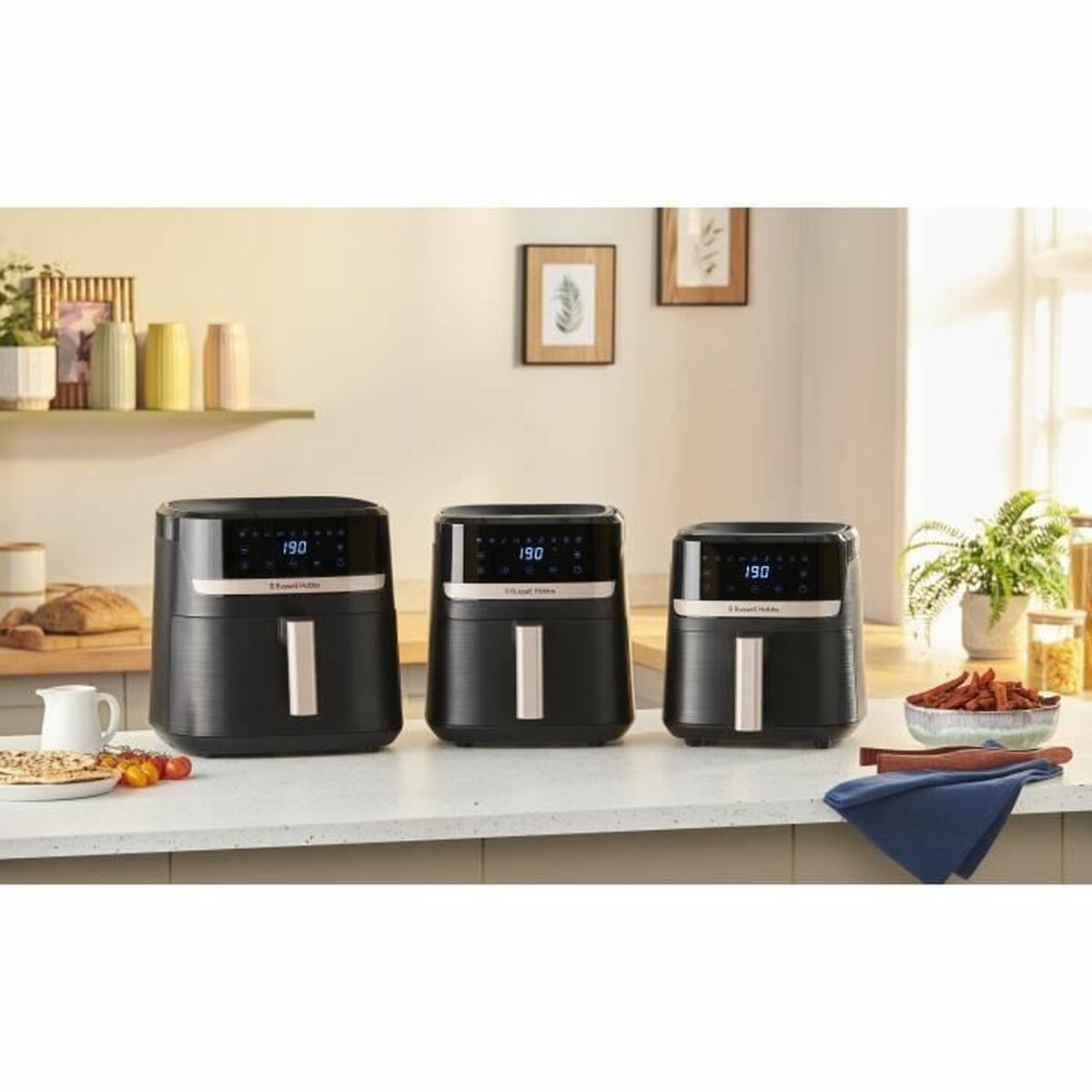 Moderne Heißluftfritteusen in der Küche – gesundes Kochen mit wenig Öl, mehrere Air Fryer Geräte auf einer hellen Arbeitsfläche.