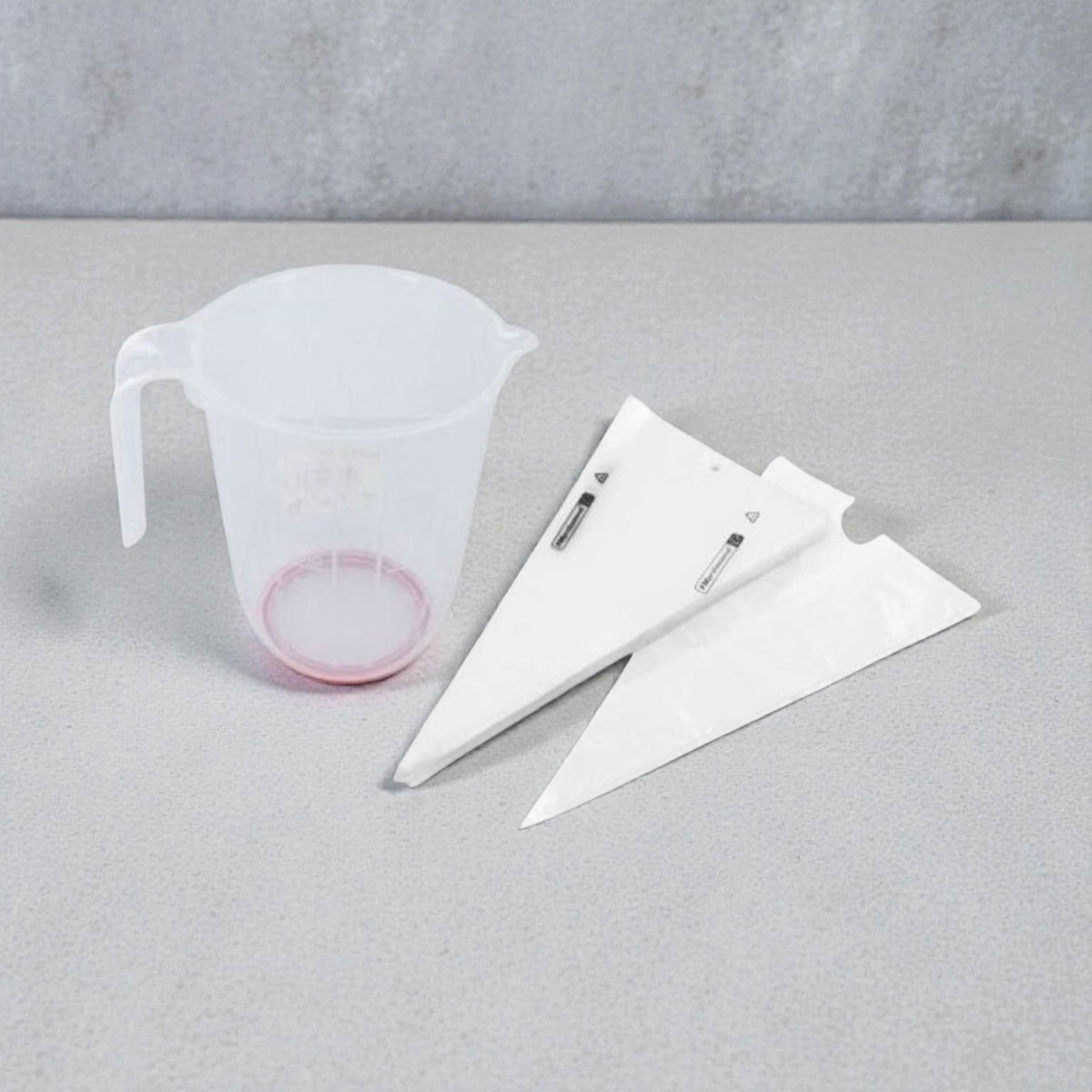 Messbecher aus Kunststoff mit Griff und Spritztüten zum präzisen Dosieren und Dekorieren beim Backen