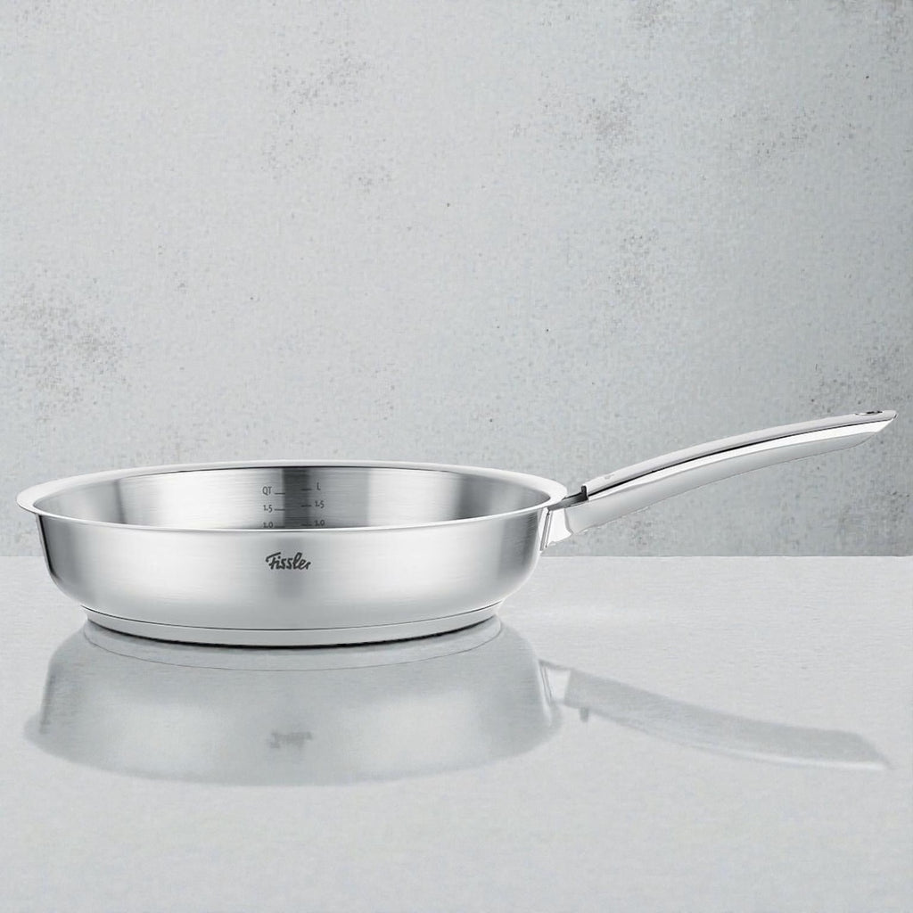 Edelstahlpfanne mit Messskala und ergonomischem Griff auf heller Oberfläche