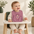 Trixie Baby Bio-Baumwoll-Lätzchen Mrs. Peacock – Baby im Hochstuhl