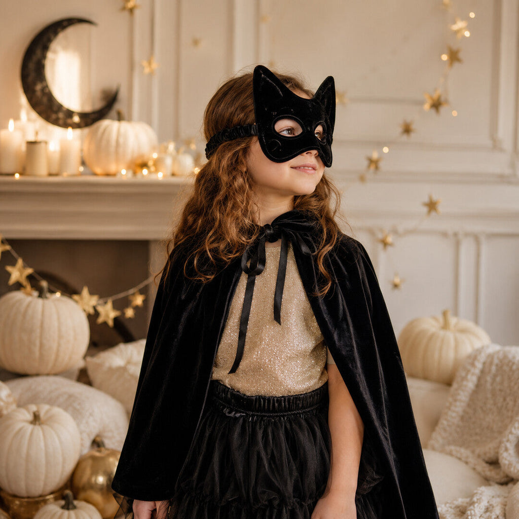 Kind mit schwarzer Samt-Katzenmaske in einer eleganten Spielszene