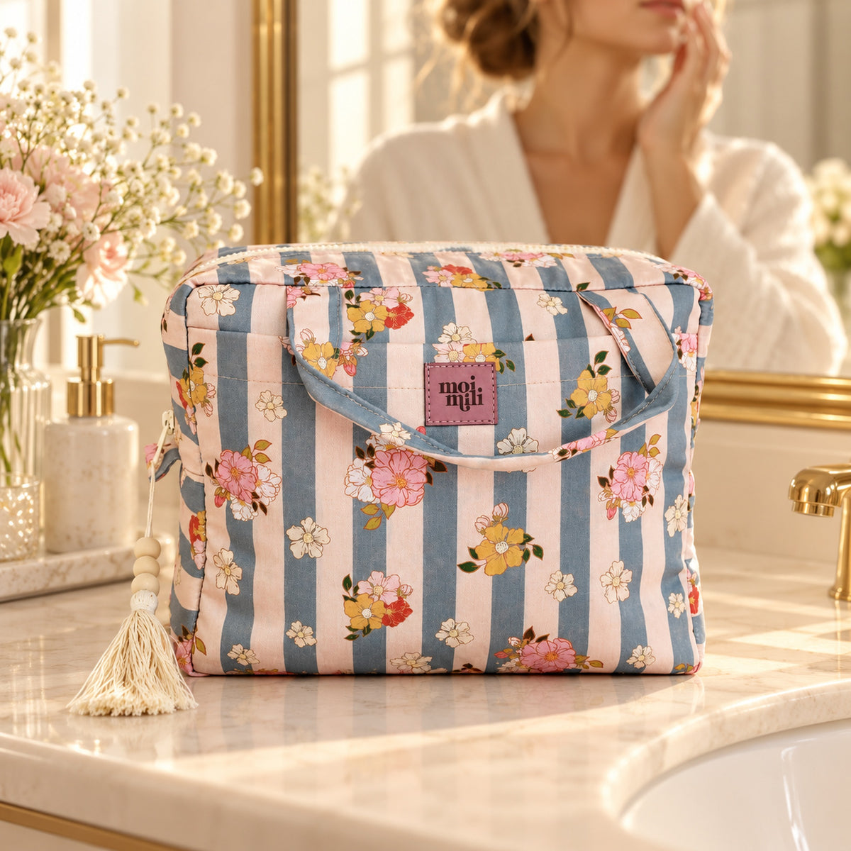Große Kosmetiktasche Blau Stripes auf einem hellen Waschtisch, Frau im Hintergrund
