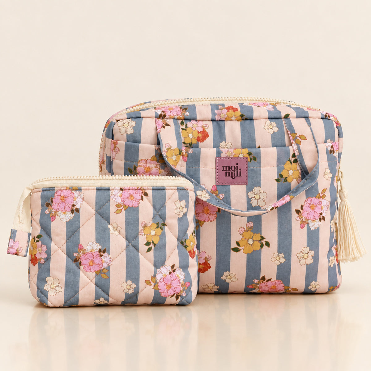 Kosmetiktaschen-Set Blau Stripes mit zwei floralen Taschen auf hellem Spiegelboden