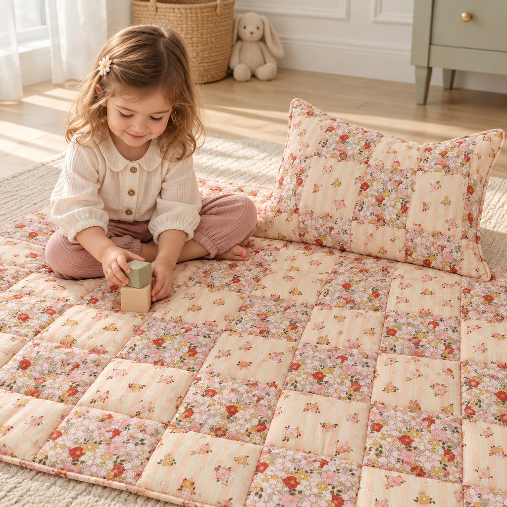 Gesteppte Patchworkdecke mit Kissen – Spring Garden, Klein – Kind spielt neben Decke und Kissen