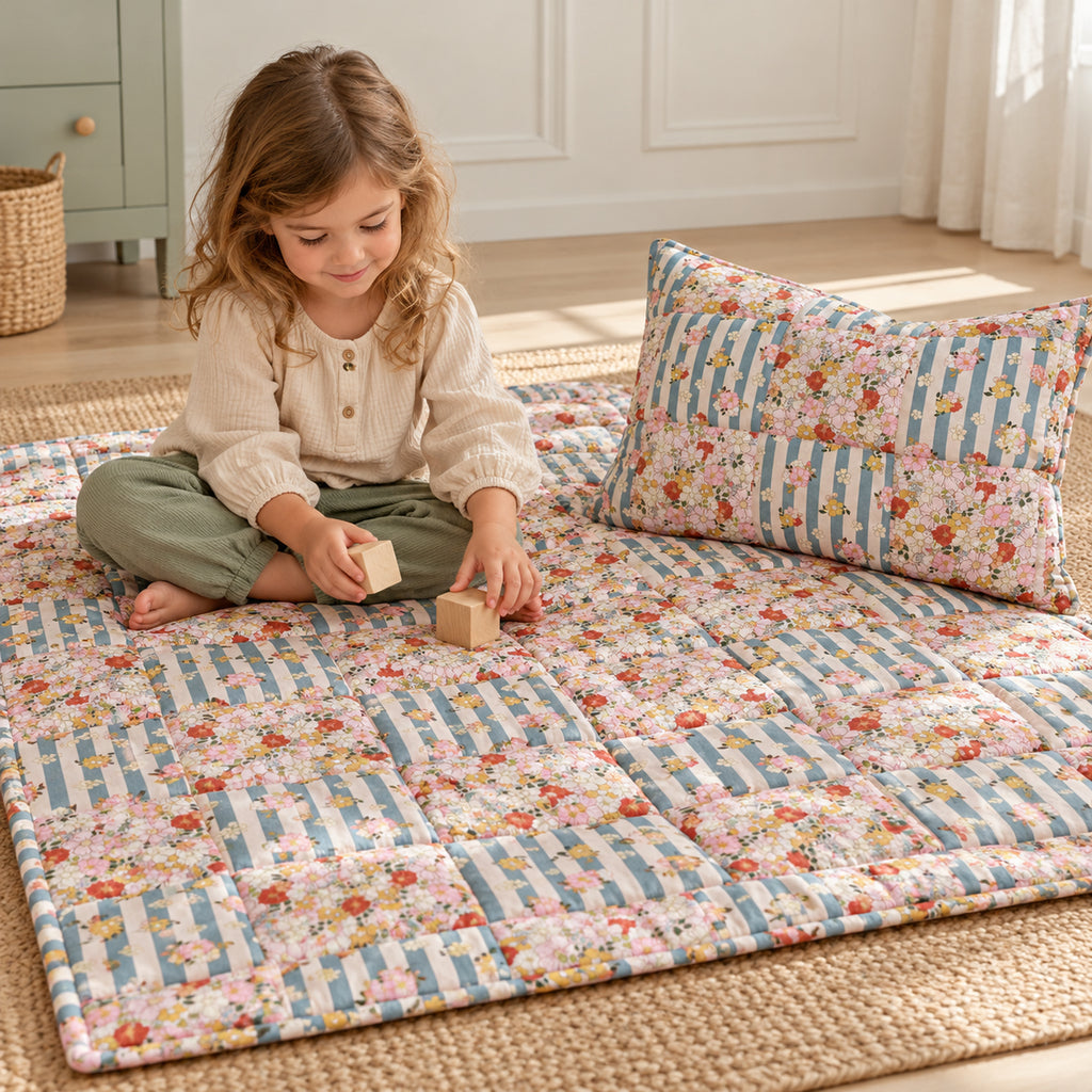 Gesteppte Patchworkdecke mit Kissen – Summer Garden, Klein – Kind spielt neben Decke und Kissen