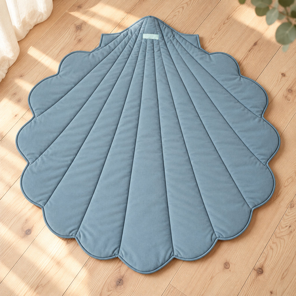 Muschel-Spielmatte aus Bio-Baumwolle – Blau – Premium Produktansicht auf hellem Holzboden