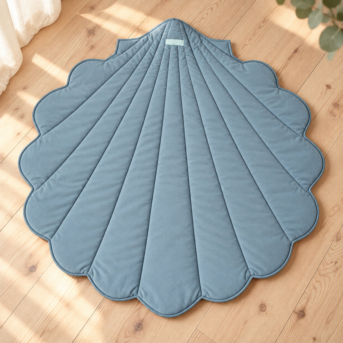 Muschel-Spielmatte aus Bio-Baumwolle – Blau – Premium Produktansicht auf hellem Holzboden