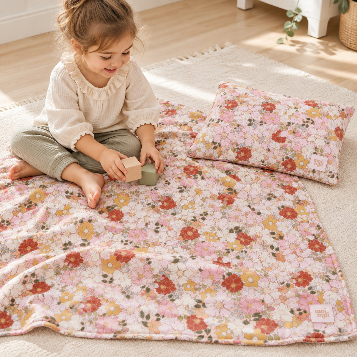 Musselin-Babydecke mit Kissen – Spring Garden – Kind spielt neben Decke und Kissen