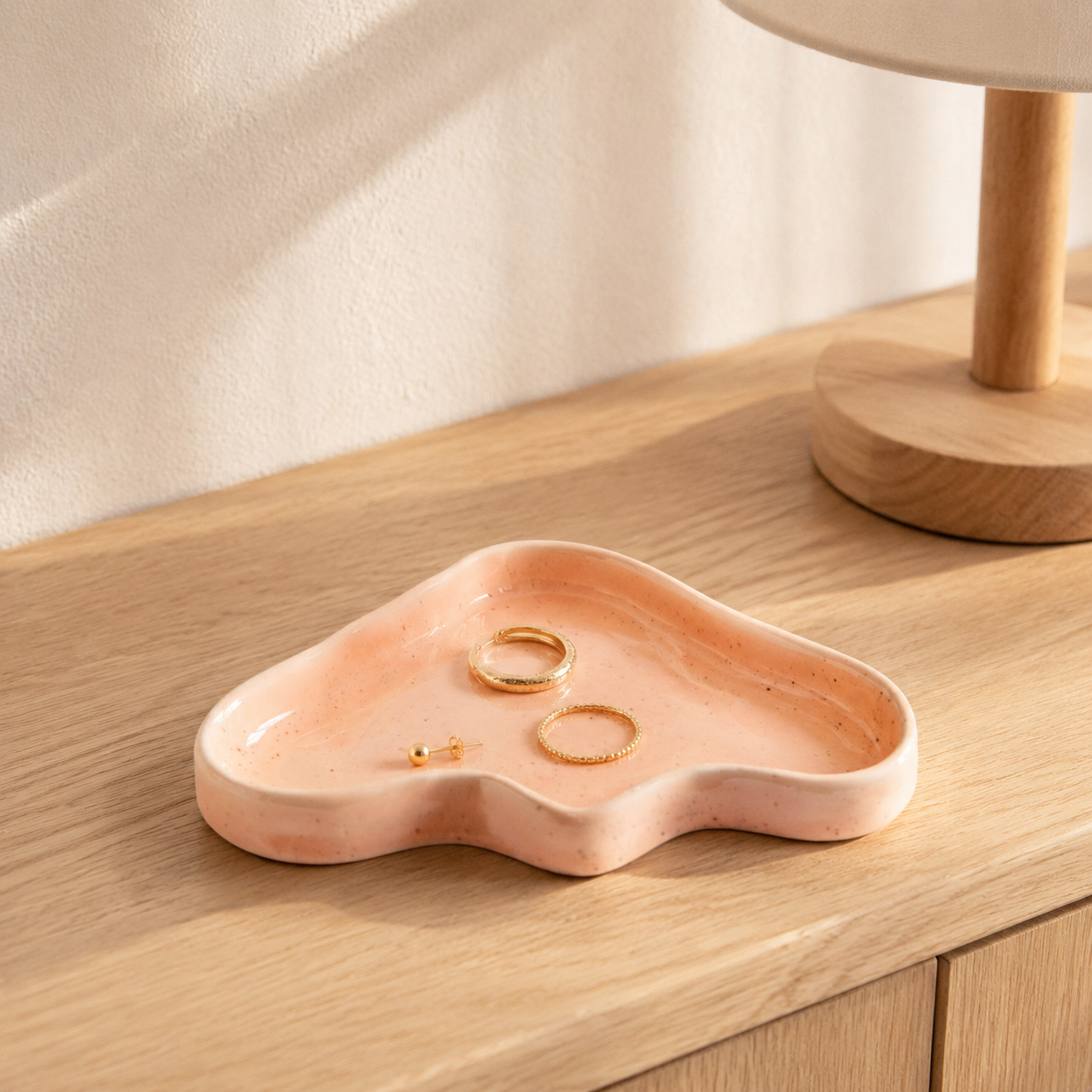 Pfirsichfarbene Keramik-Ablageschale Wave als Schmuckschale auf Eichenholz