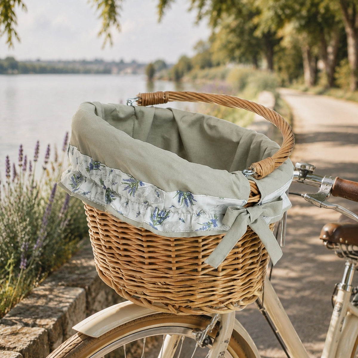 Maxian Weidenkorb am Fahrrad auf einem sonnigen Uferweg