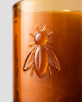 Scented candle in embossed glass — Embossed bee detail | Generated by Modelize