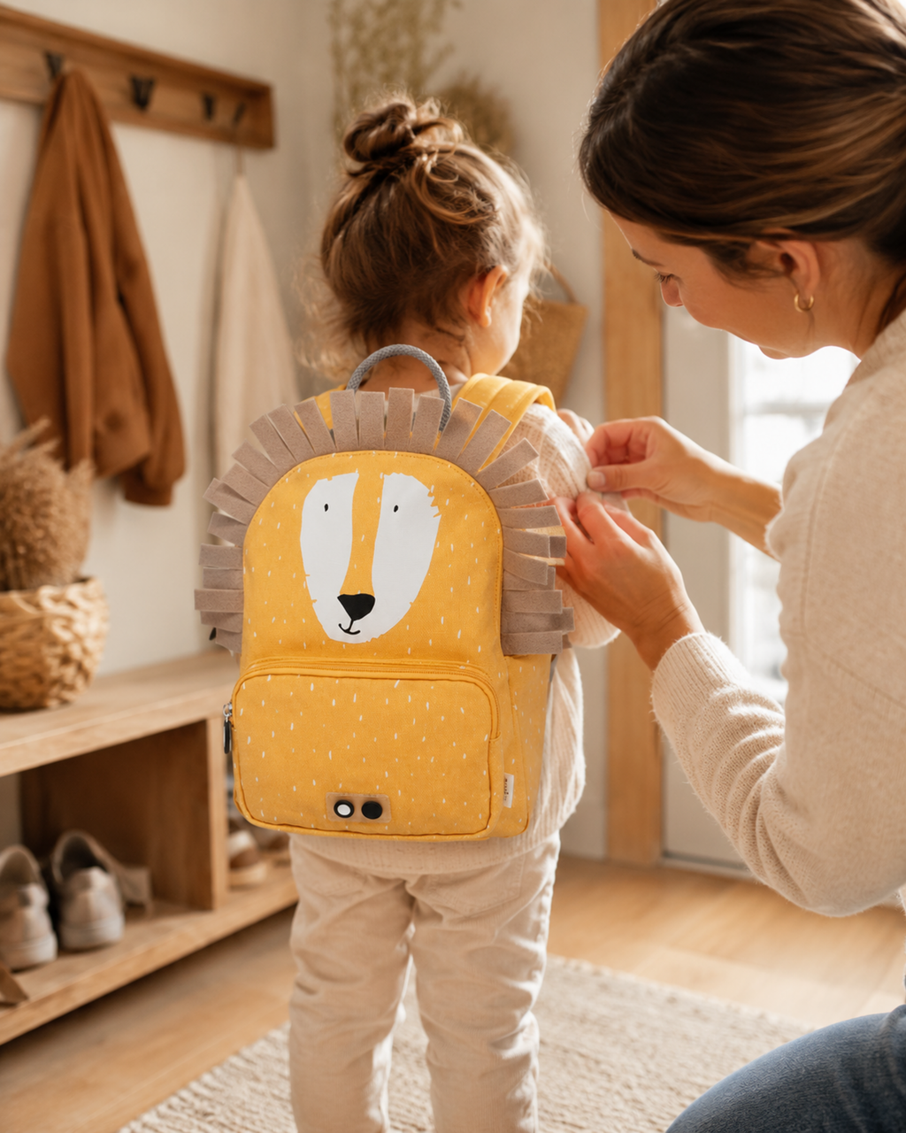 Mutter hilft Kind mit Kinder-Rucksack Mr. Lion