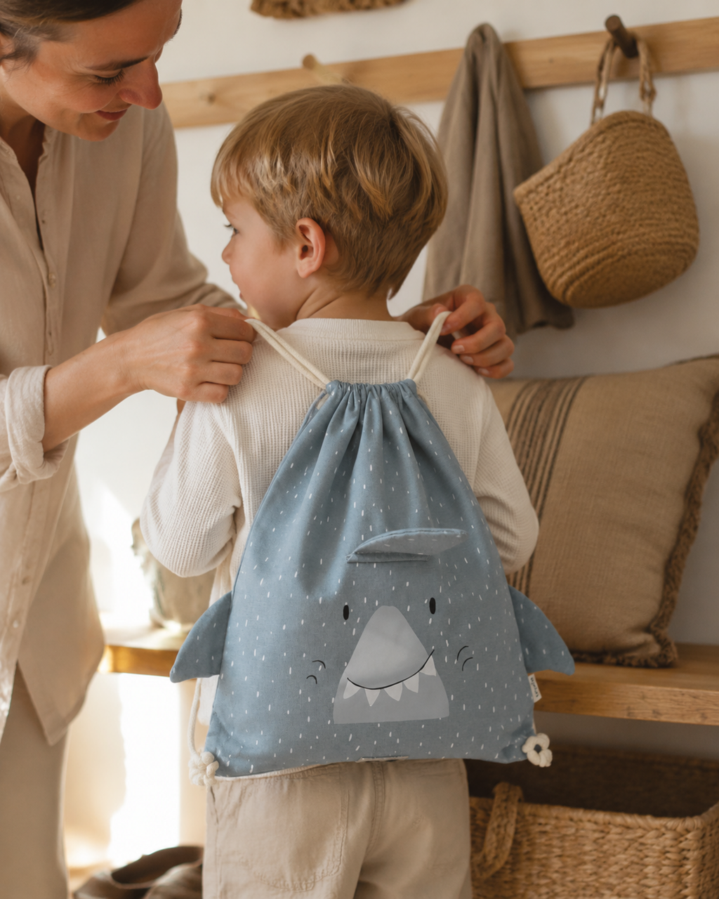 Mutter hilft Kind mit Turnbeutel Mr. Shark