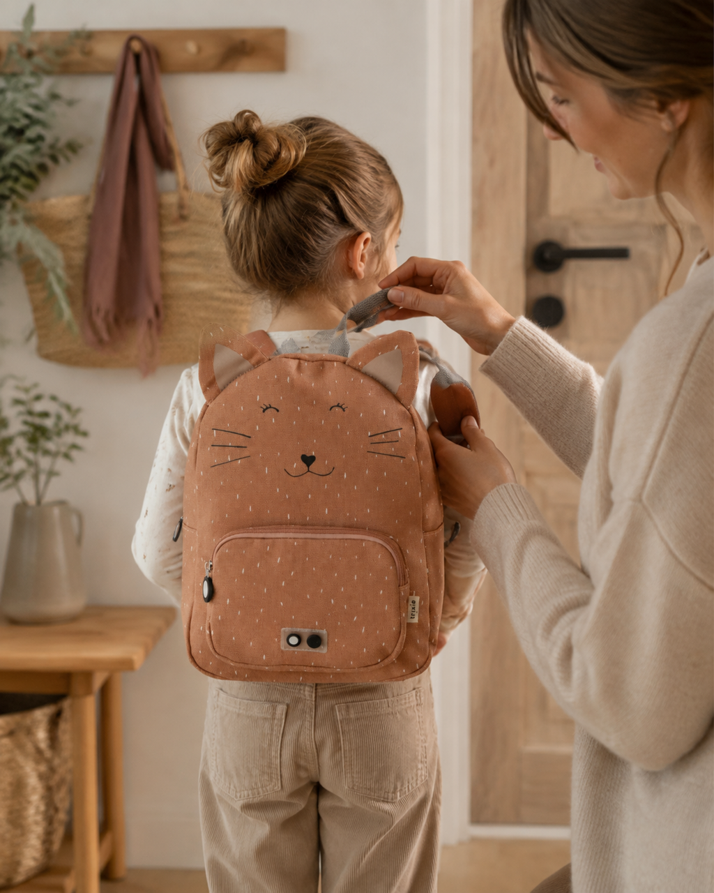 Mutter hilft Kind mit Kinder-Rucksack Mrs. Cat