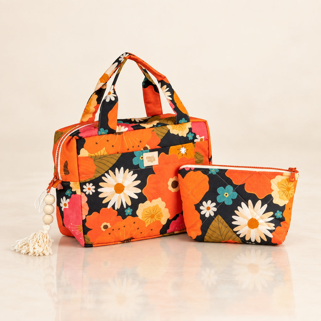 Zweiteiliges Kosmetiktaschen-Set Blumenpicknick mit orangefarbenen Blüten auf hellem Spiegelboden