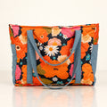 Mom Bag und Weekender Blumenpicknick mit orangefarbenem Blumenmuster auf hellem Spiegelboden