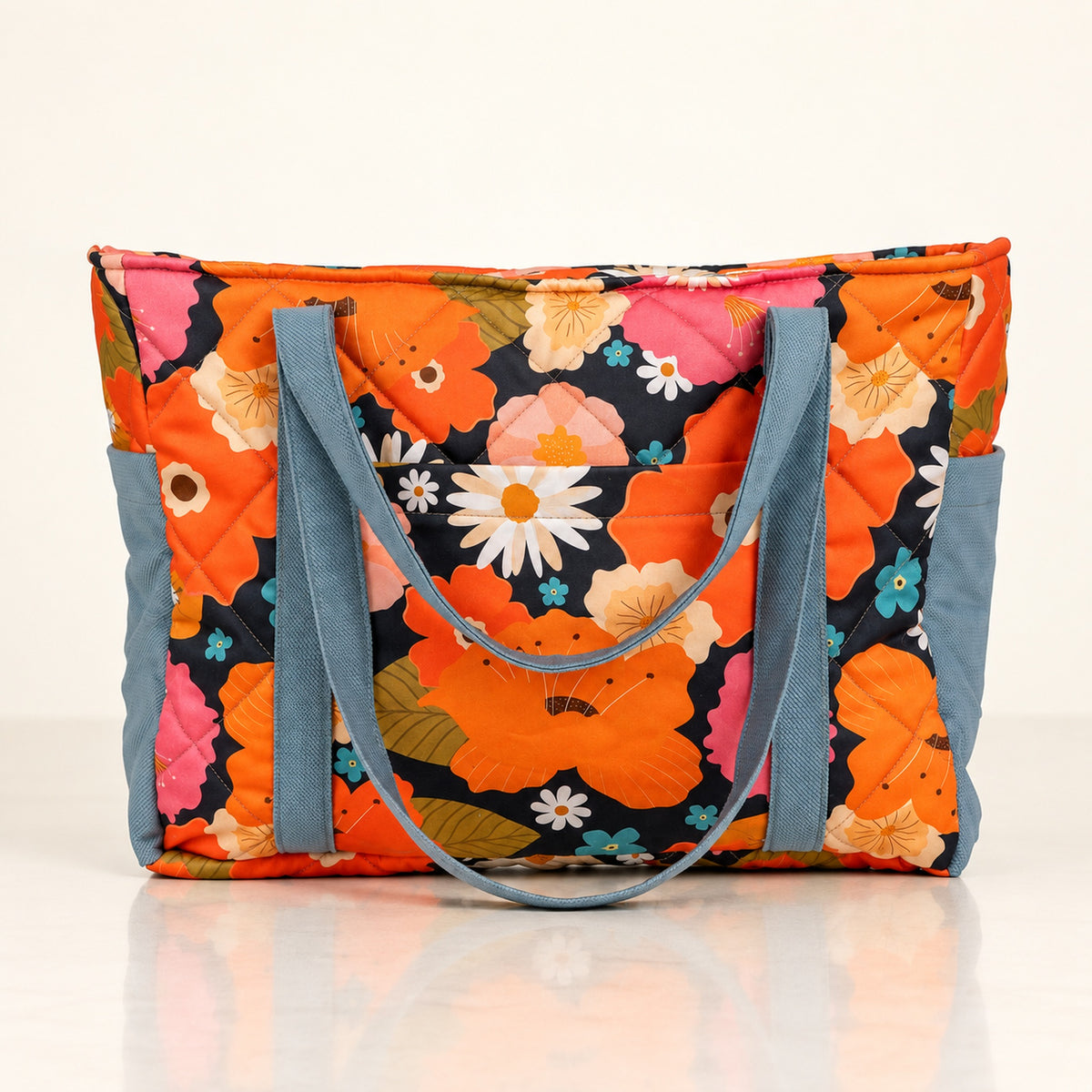 Mom Bag und Weekender Blumenpicknick mit orangefarbenem Blumenmuster auf hellem Spiegelboden