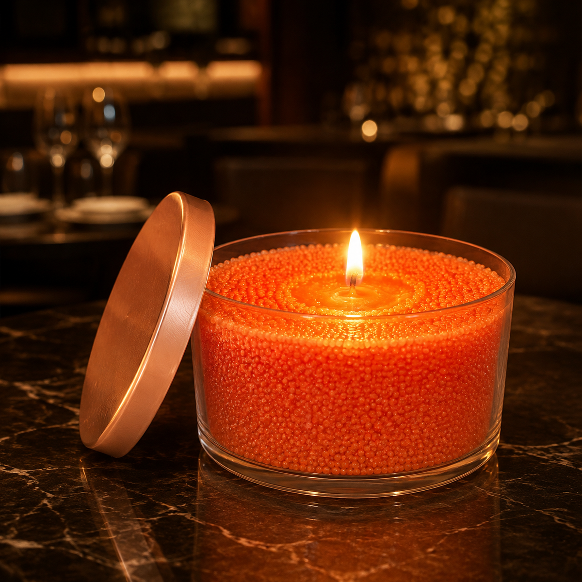 Orange Pulverkerze im Glas mit warmer Flamme in eleganter Abendstimmung