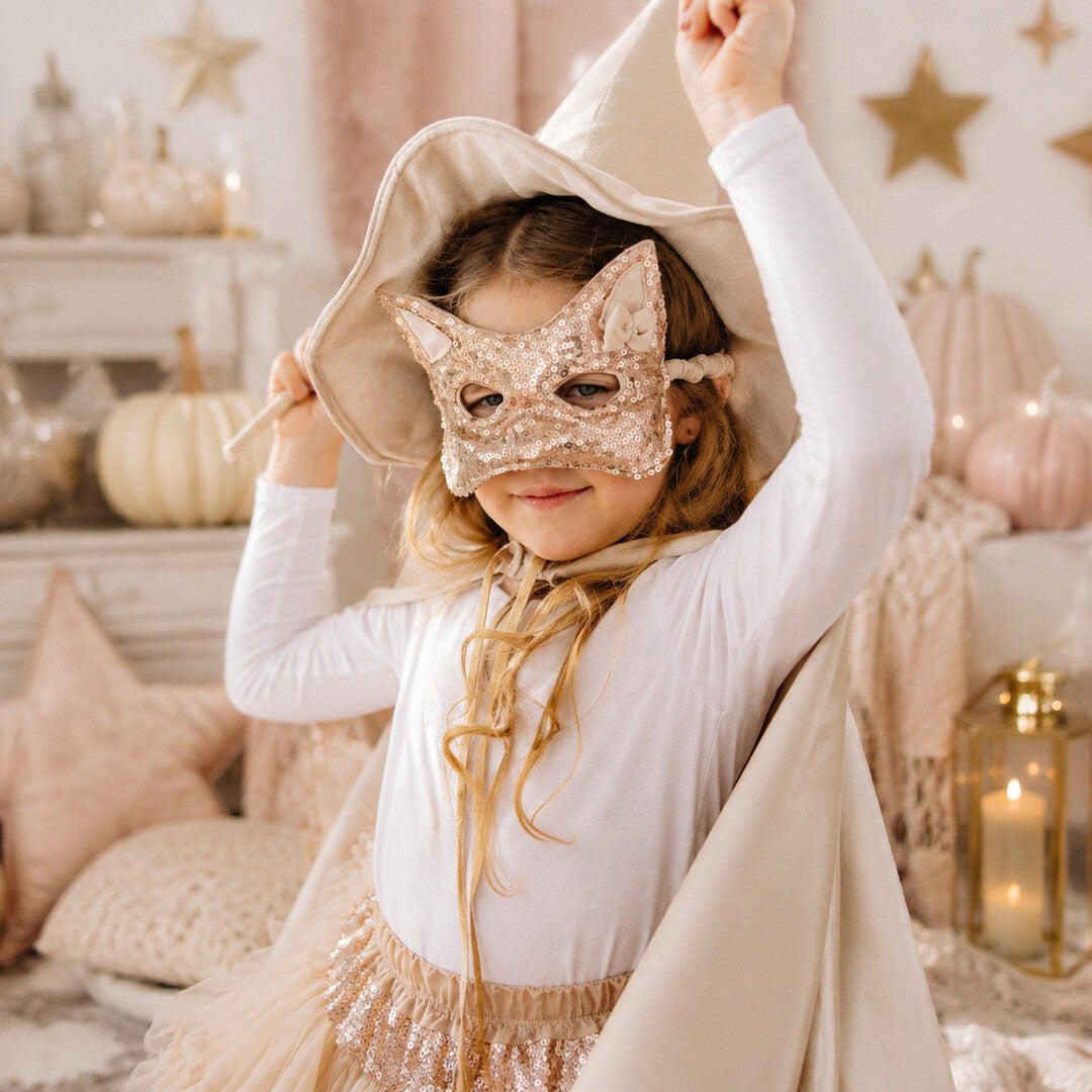 Kind mit roségoldener Pailletten-Katzenmaske beim fantasievollen Spielen