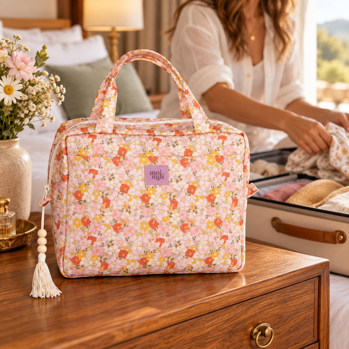 Große Kosmetiktasche Spring Garden mit zartem Blumenmuster im Hotelzimmer beim Packen einer Reise
