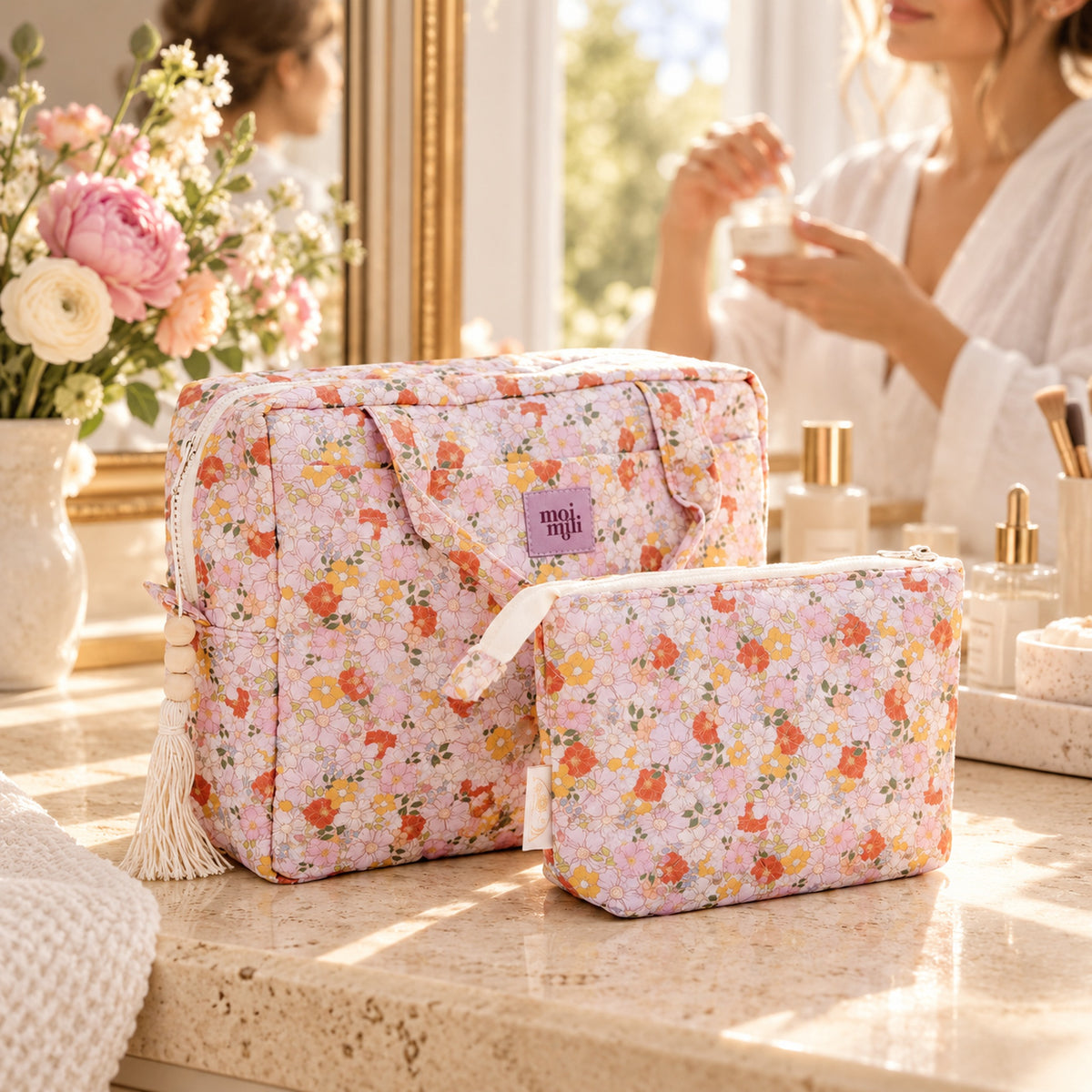 Kosmetiktaschen-Set Spring Garden auf einem hellen Waschtisch, Frau bei der Pflegeroutine